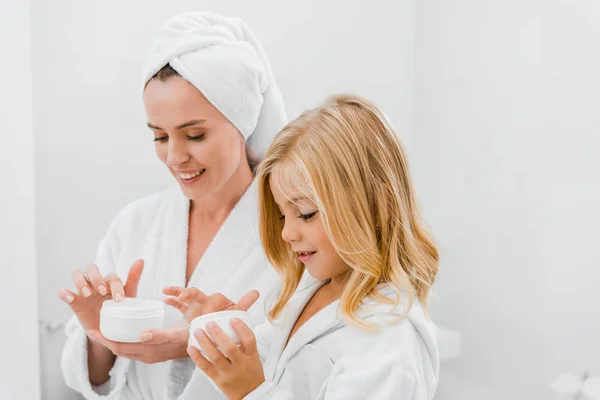 Mother Daughter Bathrobes Holding Containers Face Cream Bathroom — Stock Photo, Image