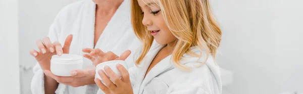 Tiro Panorâmico Mãe Filha Segurando Recipientes Com Creme Facial Banheiro — Fotografia de Stock