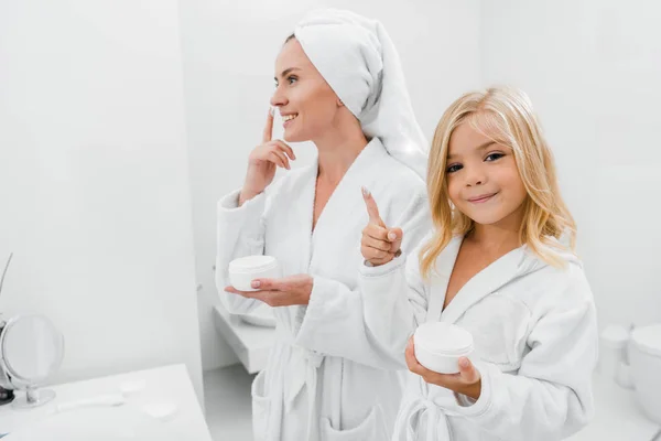 Niño Alegre Con Crema Facial Dedo Cerca Madre Atractiva Baño — Foto de Stock