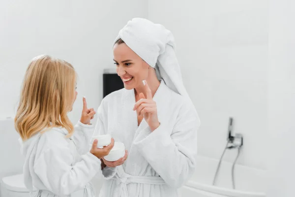 Fröhliche Mutter Und Tochter Mit Gesichtscreme Auf Den Fingern — Stockfoto