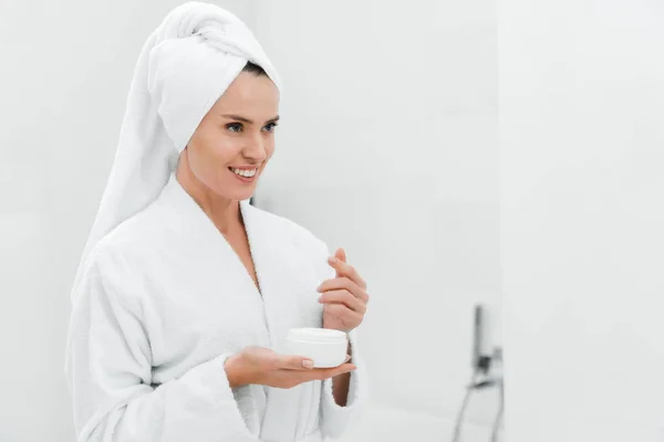 Mulher Alegre Segurando Recipiente Com Creme Facial Banheiro — Fotografia de Stock