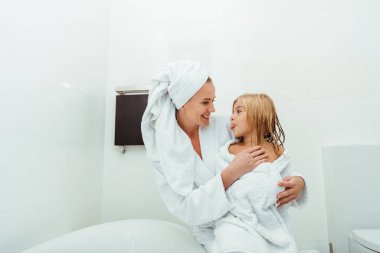 Mutlu anne gülümserken tatlı kız dilini dışarı çıkarıyor. 