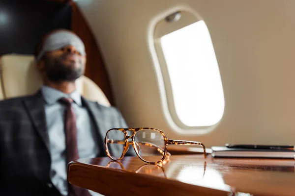 Enfoque Selectivo Gafas Mesa Cerca Hombre Negocios Afroamericano Avión — Foto de Stock