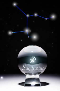 crystal ball with Sagittarius zodiac sign isolated on black with constellation