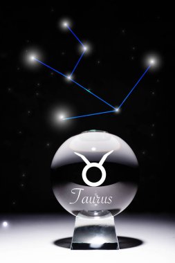 crystal ball with Taurus zodiac sign isolated on black with constellation clipart