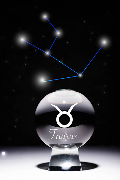 crystal ball with Taurus zodiac sign isolated on black with constellation