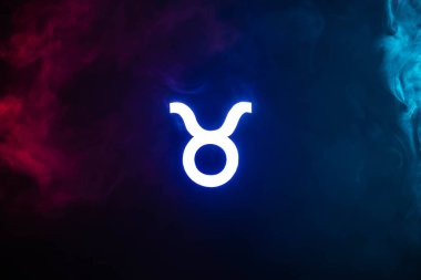 blue illuminated Taurus zodiac sign with colorful smoke on background clipart