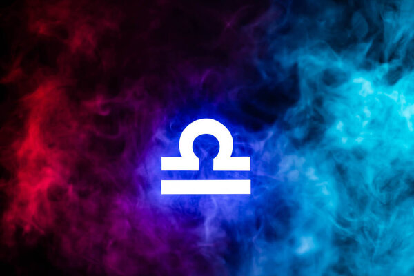 blue illuminated Libra zodiac sign with colorful smoke on background