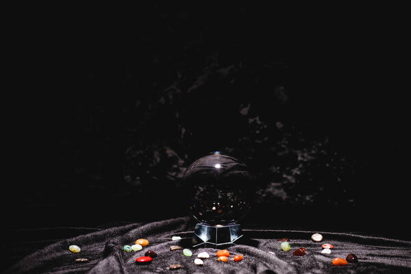 crystal ball with fortune telling stones on black velvet cloth