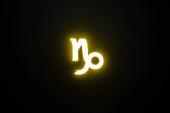 gelb beleuchtetes Tierkreiszeichen Steinbock isoliert auf schwarz