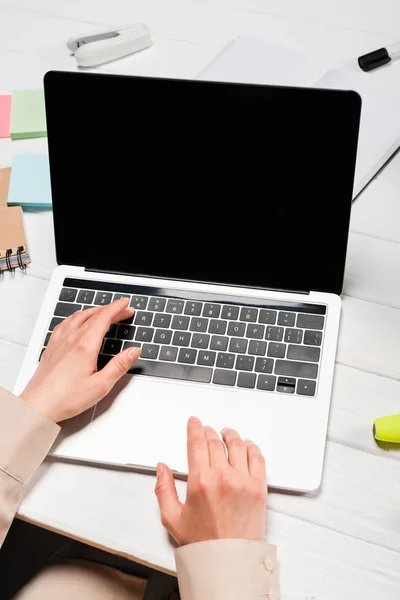 妇女在有办公用品的工作场所使用笔记本电脑的剪影 — 图库照片