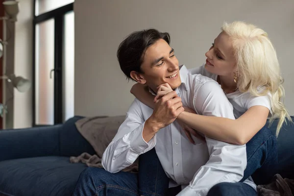 Smiling Young Couple Hugging Holding Hands Sofa Living Room — Stock Photo, Image