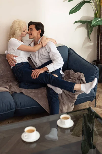 Enfoque Selectivo Pareja Sonriente Abrazándose Sofá Junto Las Tazas Café —  Fotos de Stock