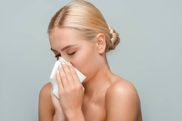 обнаженная женщина с закрытыми глазами, держащая ткани изолированы на сером
 