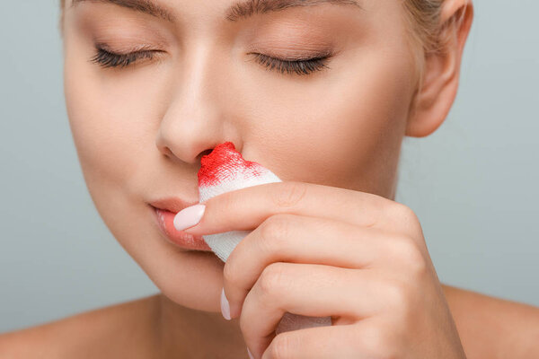 раненая женщина с повязкой с кровью, изолированной на серой
 