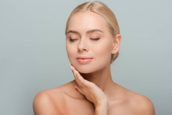 pretty woman touching clean face isolated on grey 