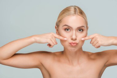 Gri renkte izole edilmiş temiz yüzlü çıplak bir kadın. 