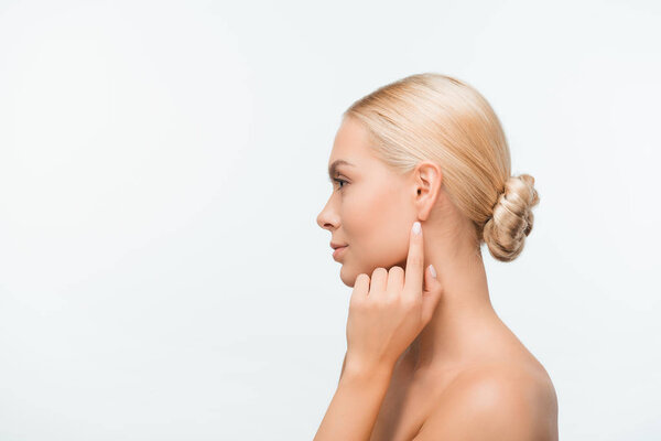 side view of naked young woman pointing with finger at ear isolated on white 