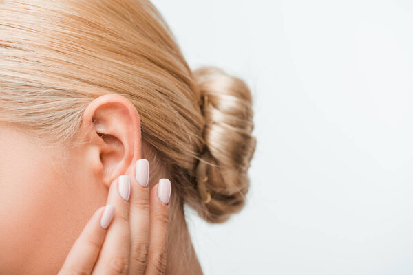 cropped view of blonde woman touching ear isolated on white 