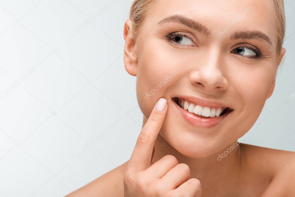 happy woman pointing with finger at face isolated on white 
