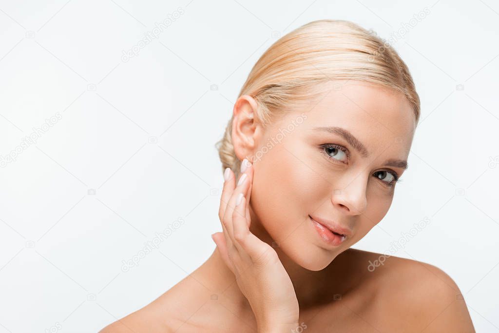 pretty naked woman touching face and looking at camera isolated on white 