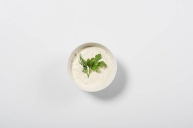 Top view of tasty tzatziki sauce with greenery on white background clipart