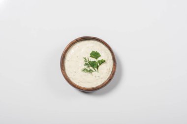Top view of homemade tzatziki sauce in wooden bowl on white background clipart