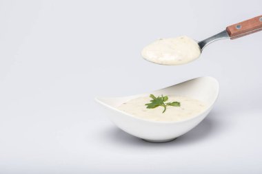 Beyaz arka planda kaşıkla ev yapımı tzatziki sosu