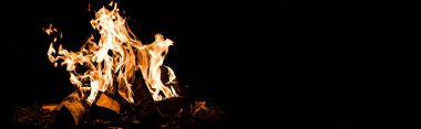 panoramic shot of logs burning in camp fire in darkness  clipart