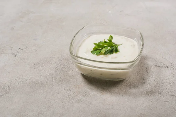 Ev yapımı lezzetli tzatziki sosu ve taş yüzeyinde yeşillik.