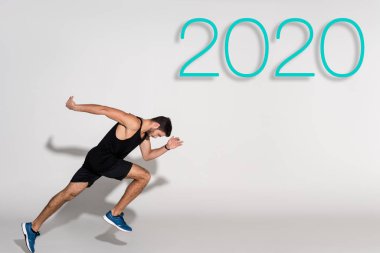 2020 harfli beyaz arkaplanda koşan sporcunun yan görünümü