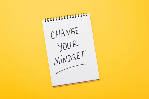 随着你的思维方式的改变而改变你在黄色表面上的笔记的顶部视图 — 图库照片