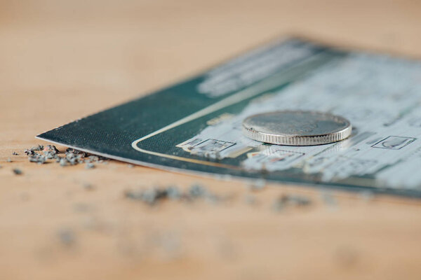 селективный фокус серебряной монеты на использованном лотерейном билете
