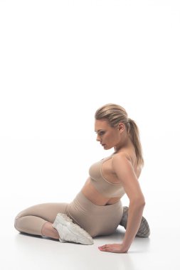 Bej taytlı seksi sarışının arka plan görüntüsü beyaz zeminde kıvrılıp duruyor.