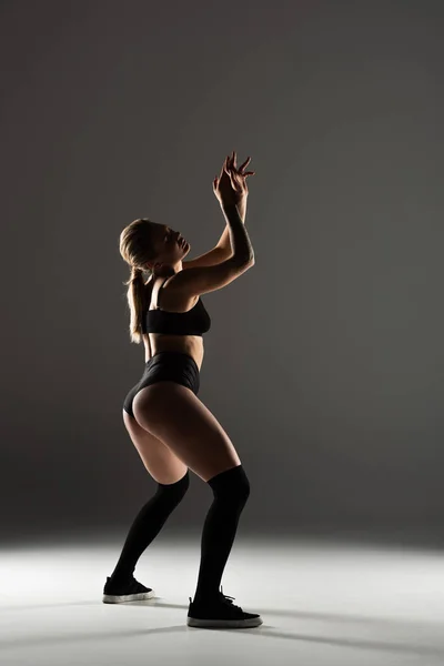 Seitenansicht Von Sexy Mädchen Schwarzen Outfit Twerking Schatten Auf Grauem — Stockfoto