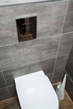 Modern tuvalette gri fayanslı ve tuvalet fırçalı seramik temiz klozet.