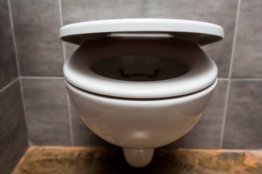 close up view of ceramic clean toilet bowl with lid in modern restroom  clipart