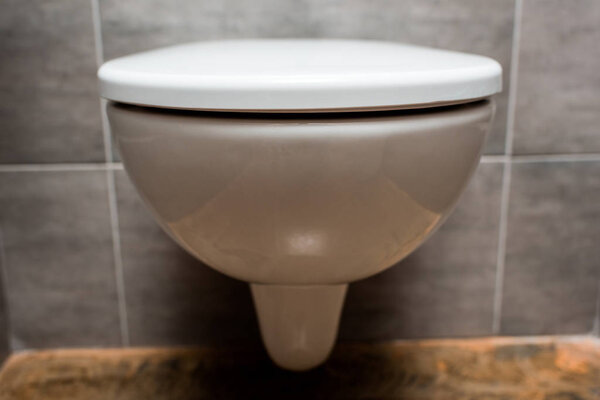 close up view of ceramic clean toilet bowl with lid in modern restroom 