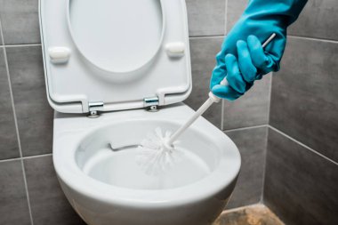 Modern tuvaletlerde seramik tuvalet fırçası ve gri fayanslı tuvalet temizleme manzarası.