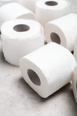 close up view of rolls of toilet paper on grey textured surface clipart