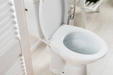 white modern bathroom with toilet bowl near folding screen clipart