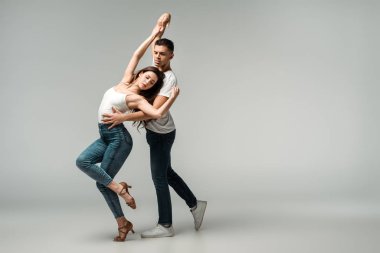 Gri arka planda dans eden kapalı gözlü dansçılar. 