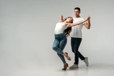 Gri arka planda dans eden kapalı gözlü dansçılar. 