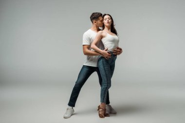 Gri arka planda dans eden kapalı gözlü dansçılar. 