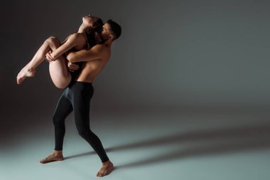 Seksi dansçılar karanlık arka planda fotokopi alanı ile çağdaş dans ediyorlar 