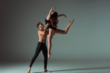 Seksi dansçılar karanlık arka planda fotokopi alanı ile çağdaş dans ediyorlar 