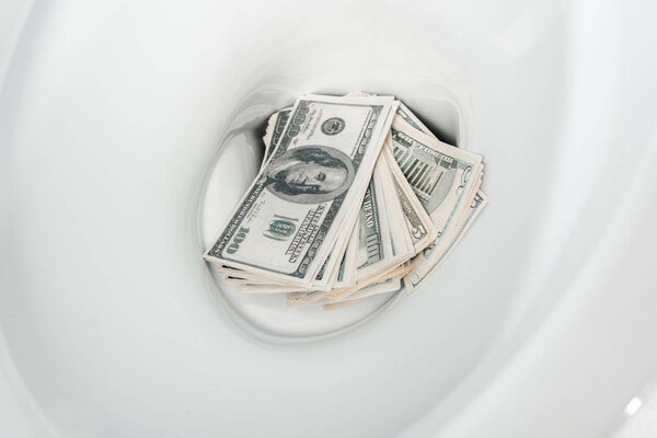 close up view of money in ceramic clean toilet bowl