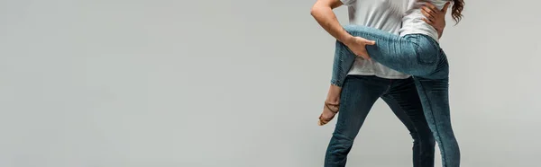 Tシャツとジーンズでバカータを踊るダンサーのパノラマ写真です — ストック写真