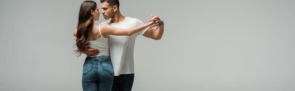 панорамный снимок танцоров, танцующих бачату, изолированных на сером
 