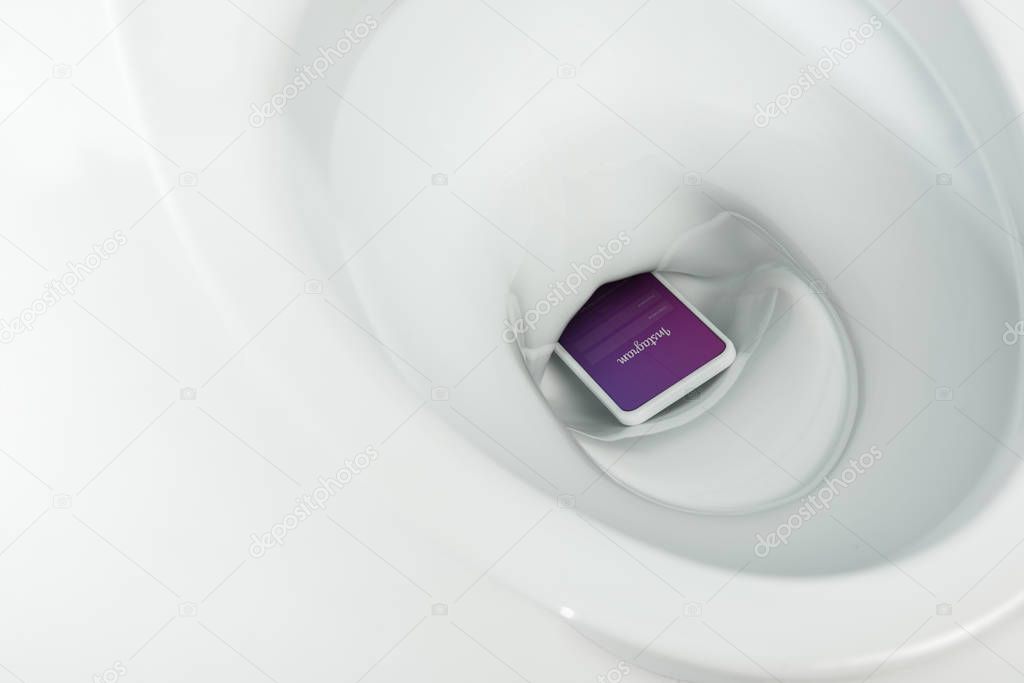 KYIV, UKRAINE - NOVEMBER 7, 2019: close up view of smartphone with  instagram app in ceramic clean toilet bowl isolated on white
